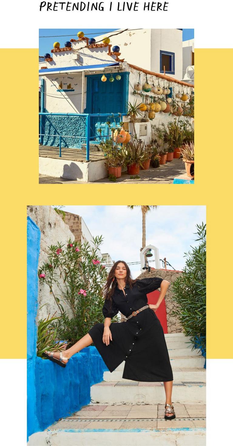 Woman in black linen dress with foot on blue wall